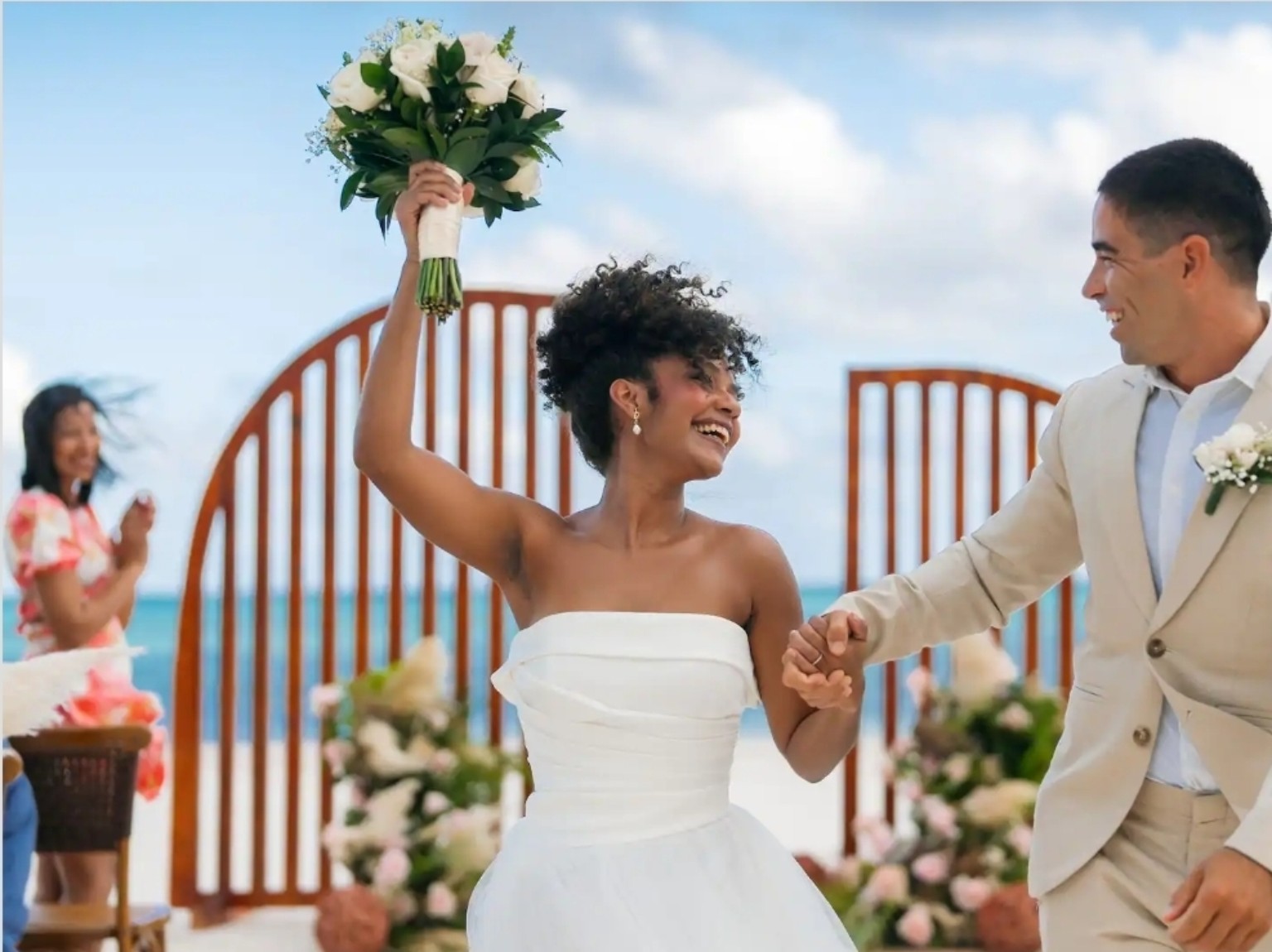 A couple celebrating their beach wedding at a Secrets or Dreams resort